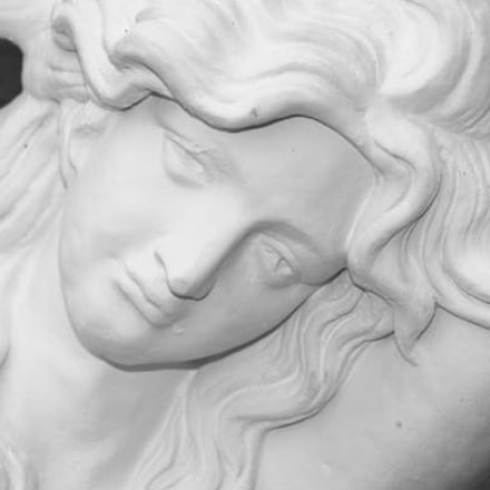 Detail eines weißen Marmorreliefs mit dem Gesicht einer Frau, wie es im Lokal steht